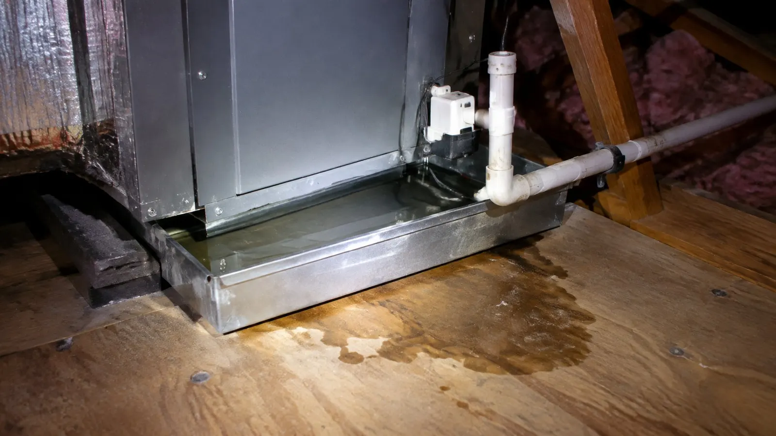 Water sitting in an air handler's drain pan in an attic, with a float switch on the drain line