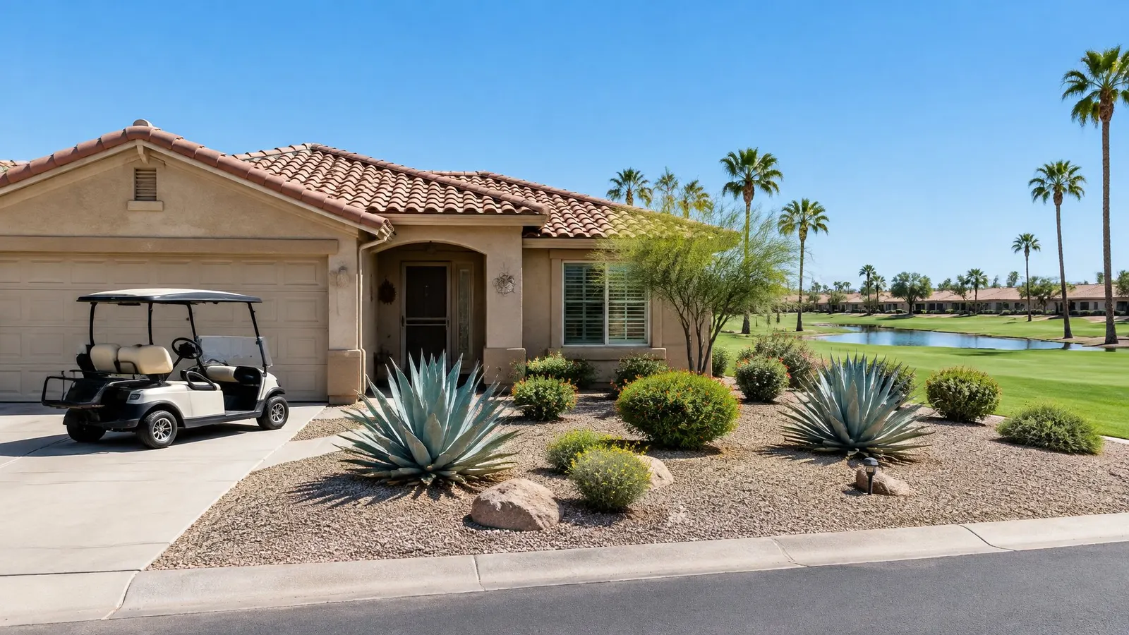 Single-storey stucco home with a tile roof, a golf cart in the driveway and a fairway behind in Sun Lakes